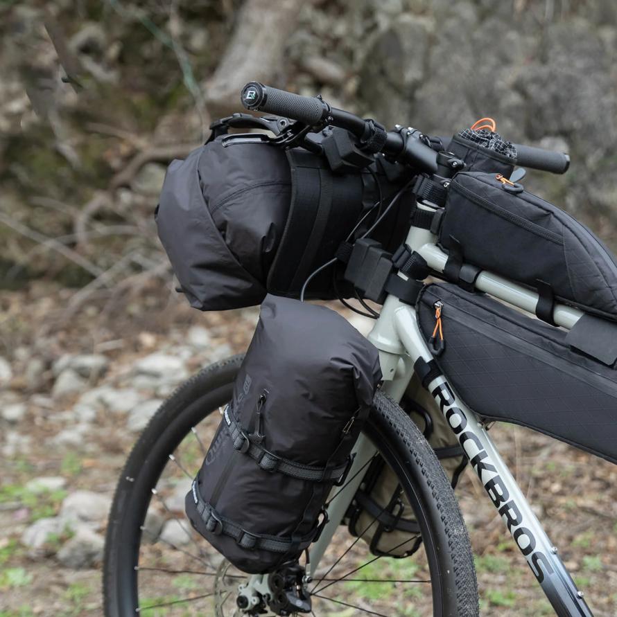 ROCKBROS bolsa de compresión impermeable negra montada en bicicleta en entorno de montaña